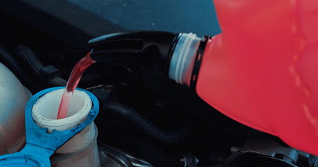 engine oil pouring from canister into motor of car