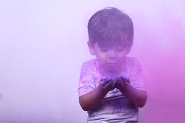Little boy plays with Holi festival colours.Concept for Indian festival Holi.