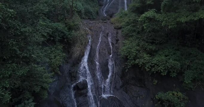 Scenic Cascades On Steep Slope Rocky Mountain In Rainforest Of Cotigao Wildlife Sanctuary In South Goa, India. - Aerial Pullback Shot