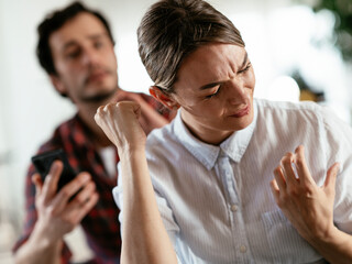 Husband and wife are arguing at home. Angry man is yelling at his wife.