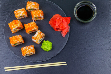 Sushi rolls Philadelphia on a black slate. Top view