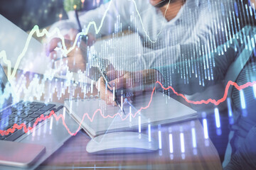 Double exposure of forex chart drawing over people taking notes background. Concept of financial analysis
