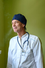 smoking male doctor in white uniform uniform with stethoscope