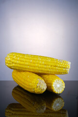 Cooked sweet corn with reflection on glass table