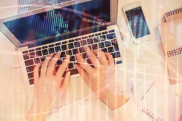 Double exposure of woman hands working on computer and forex chart hologram drawing. Top View. Financial analysis concept.