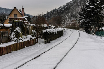 Snowy tracks leading around a small wooden hut.