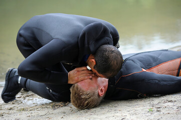 Lesson of artificial respiration. Lifeguard giving drowning mouth-to-mouth resuscitation