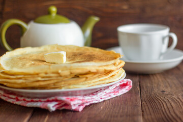 Homemade baked pancakes and tea utensils on a dark wooden table.