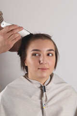 A woman cuts her hair very short with an electric razor at home. Fun and bold style