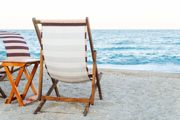 Summer beach background, scene with chairs, blue sea and sand, sunrise on the empty beach, no people