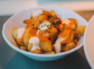 Ración de patatas bravas españolas con salsa picante y mayonesa.