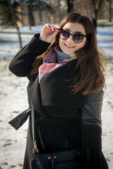 Portrait of a cheerful young girl posing in park on a sunny winters day.