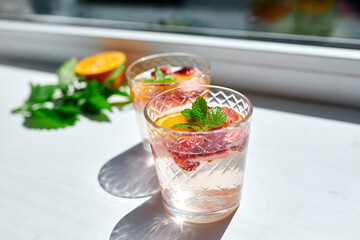 Summer cocktail with strawberry, orange and mint in glass