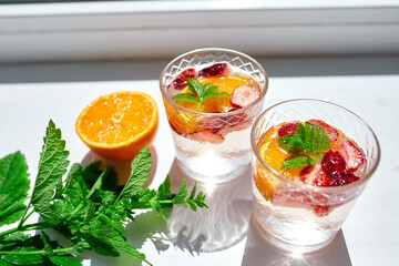 Summer cocktail with strawberry, orange and mint in glass