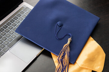 Class of 2021 graduation tassel and cap celebration with a modern computer for virtual learning...