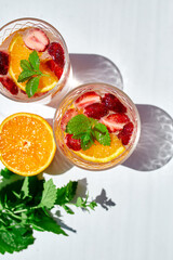 Summer cocktail with strawberry, orange and mint in glass