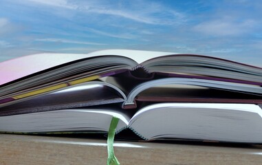 Bücherstapel geöffnete Seiten vor blaue Himmel im Freien