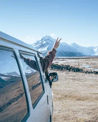 Photo sur Plexiglas Aoraki/Mount Cook Une jeune femme vit la vie de van pleine de liberté en Nouvelle-Zélande et montre un signe de paix depuis le camping-car devant le mont Cook en Nouvelle-Zélande