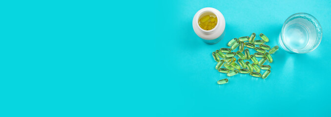 Omega 3 fish oil capsules spilling out of a bottle on a blue background. selective focus.