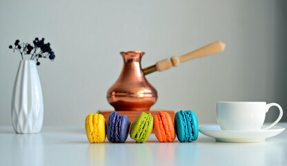 Cup of coffee, multicolored macaroons, turkish coffee pot on white background