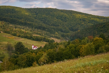 Fototapeta na wymiar White christian church in the valley in the Carpathian mountains near Svaliava, Zakarpattia region of Ukraine, summer landscape