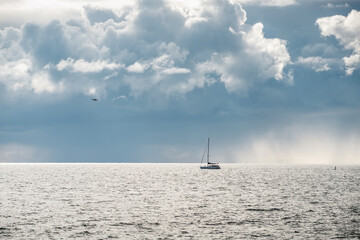 boat sailing in the sea under similar clouds