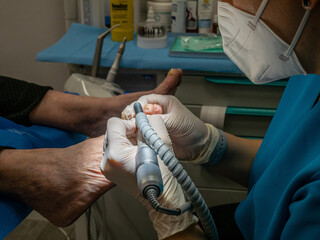 WOMAN PODIATRIST TREATING A CLIENT'S FEET