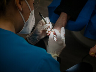 WOMAN PODIATRIST TREATING A CLIENT'S FEET