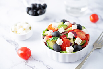 Greek Salad with ingredients in a white bowl