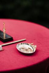 wedding rings on a tray on a red table close-up