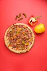 Italian Pizza with Beef tongue, Mozzarella, Bulgarian pepper, Gherkins, Onions, Dijon mustard, Oregano. Red background. Copy Space