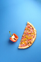 Half a piece of Pizza with Beef tongue, Mozzarella, Bulgarian pepper, Gherkins, Onions, Dijon mustard, Oregano. Blue background. Copy Space. Food concept