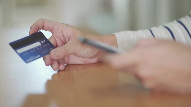 Indoor shot of men hand and smartphone.  While typing credit card mock up number information and CCV security code for online payment transaction. Digital banking with internet communication.