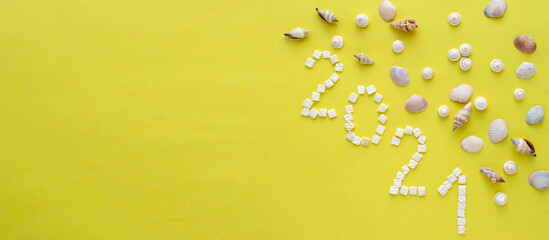 2021 on a yellow background. Numbers from mother-of-pearl shell pieces. View from above. Layout....