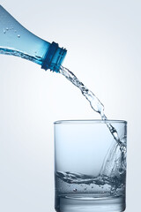 Water is poured from a bottle into a glass.