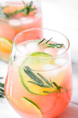 fitness cocktail in glass with lime and rosemary on white table background