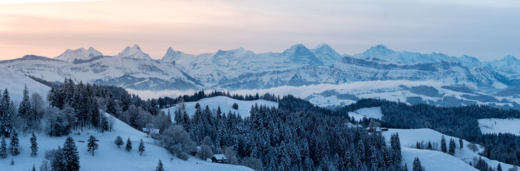 panoramic view on a beautiful winter sunrise in snowy Emmental