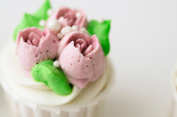 Tender cake with whipped cream. Cake in the form of flowers. Cupcake with whipped cream.