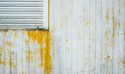 detail view on closed window and yellow weathered wall
