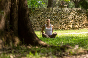Naklejka na ściany i meble blonde woman practicing yoga in a park, Barueri, São Paulo, Brazil