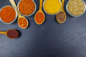 Set of different aromatic spices on black slate. Top view, copy space
