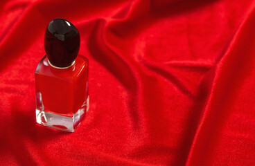 red perfume bottle on velvet red background