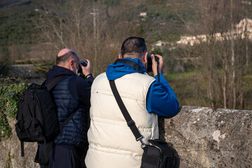 Two caucasian male photographers taking pictures of a landmark