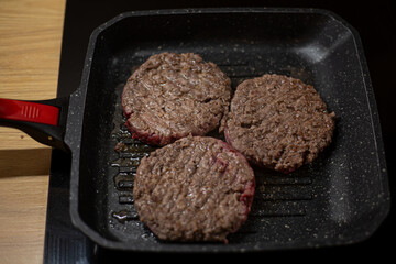 Burger minced beef meat cutlet on a grill pan. Process of cooking self made burgers at home