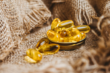 Fish oil pills, tablets on the burlap. Vitamin complex omega 3,6,9. Fish oil capsules with omega-3, vitamin D. Close up