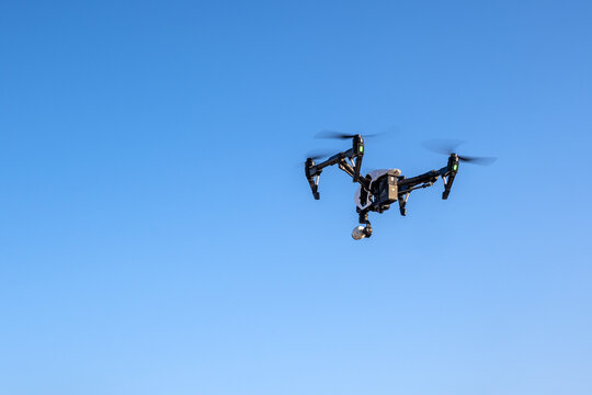 Paros, Greece - September 27, 2020: Modern drone with camera flying on a clear blue sky