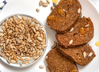 Homemade halva with peanuts and sunflowers with honey on a white plate
