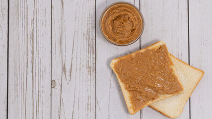 toast with peanut butter and peanuts on a gray background. copy space, top view.n a gray background. copy space