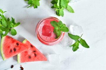 Fresh watermelon juice with mint and ice in the glass on white table.Sweet summer dessert, smoothie,cocktail healthy food concept, close up.Summertime. Copy spase. Selective focus
