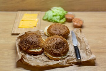 Burger bread, lettuce and cheese on the table. Process of cooking self made burgers at home